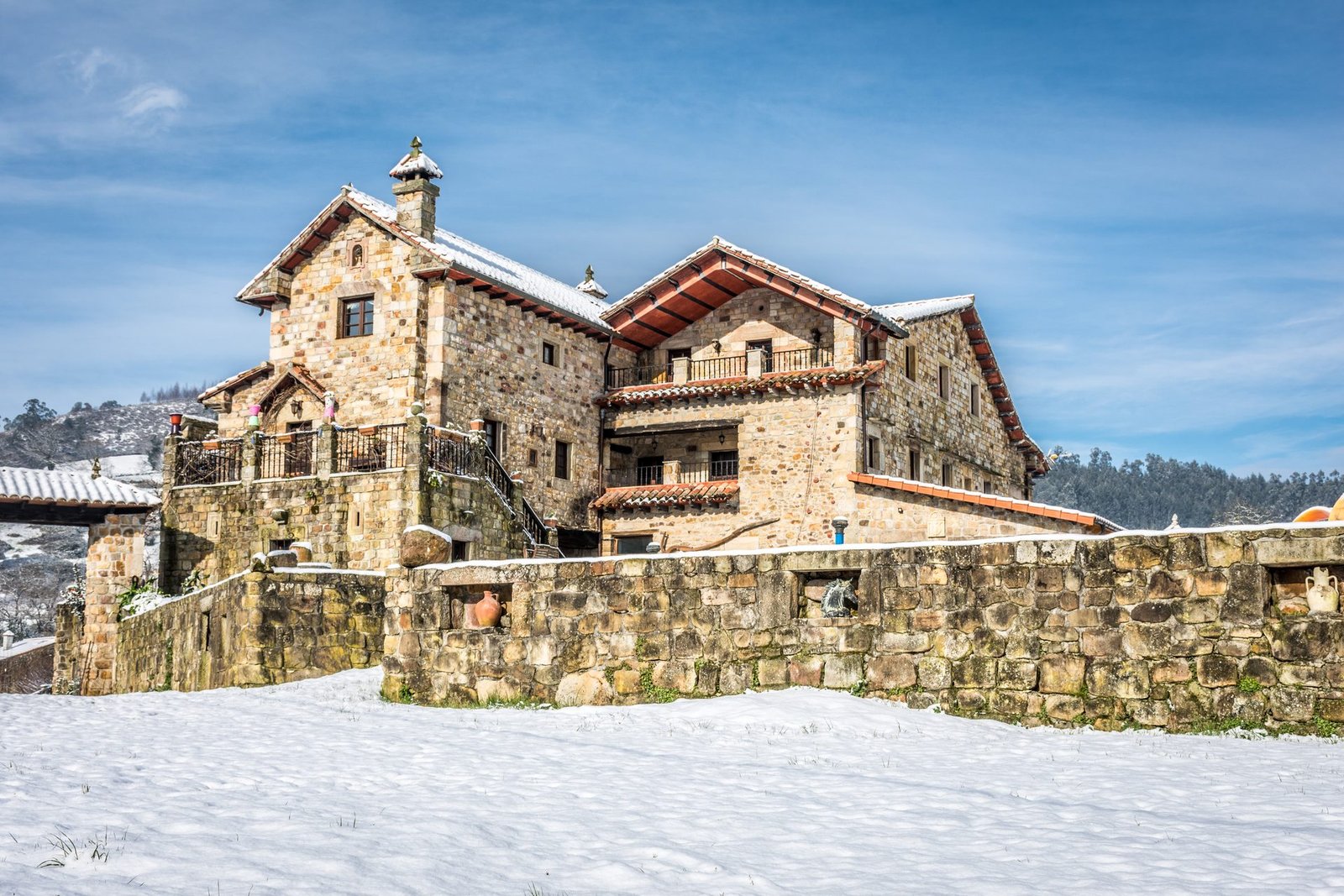 Finca Gándara nevada en invierno, casona de piedra cubierta de nieve en Cantabria